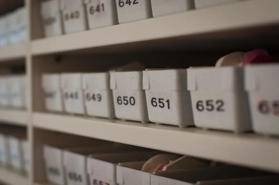 Rows of numbered white storage bins neatly arranged on shelves for home organisation