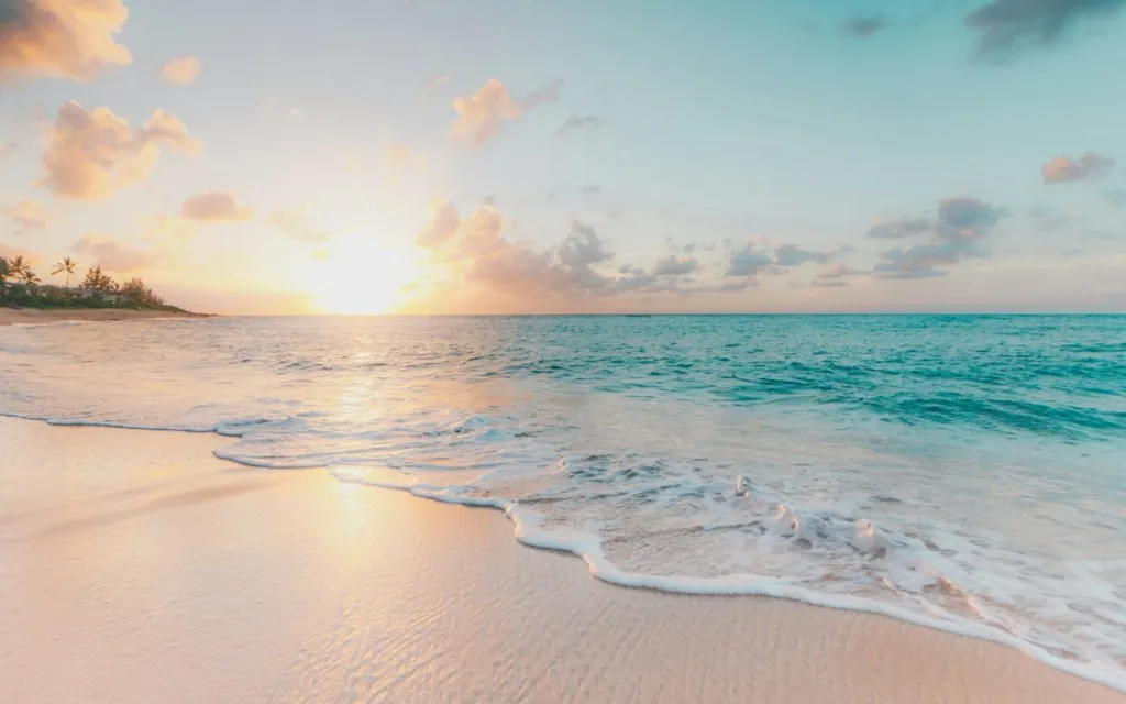 Sunny beach with turquoise water and soft waves at golden hour