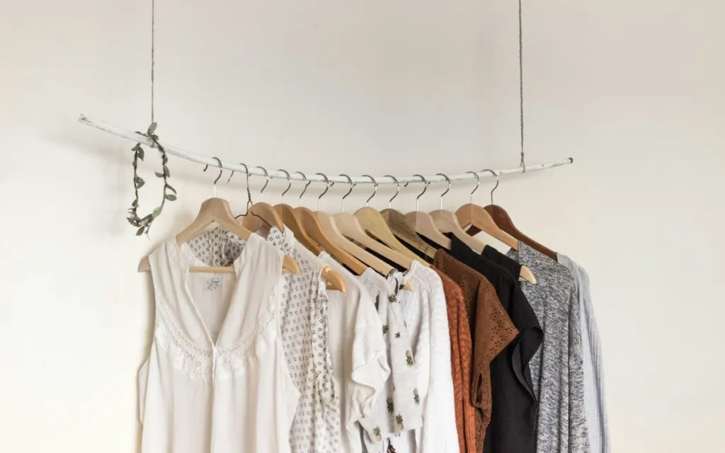 Small minimalist wardrobe of neutral clothes hanging on a rail