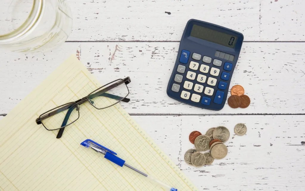 Calculator, glasses and notepad ready for monthly budget planning