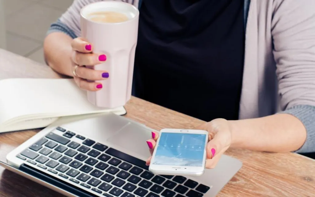 Person checking information on a phone and laptop
